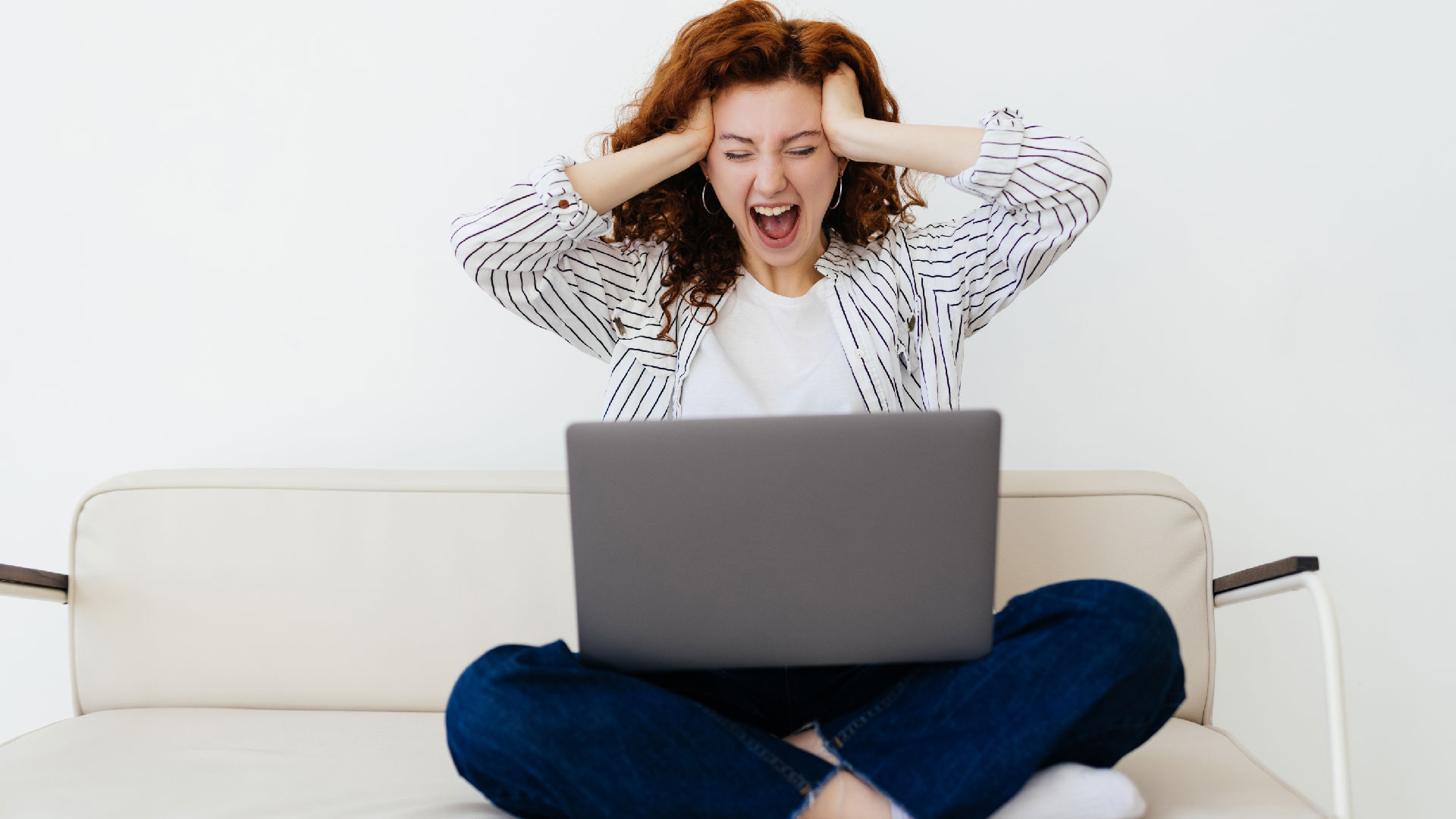 Laptop quá ồn? 5 mẹo giảm tiếng quạt đáng kinh ngạc 1 wow cute redhead woman with artificial limb sitting grey sofa looking laptop screen while feeling shocked surprised emotions spending time home concept 01