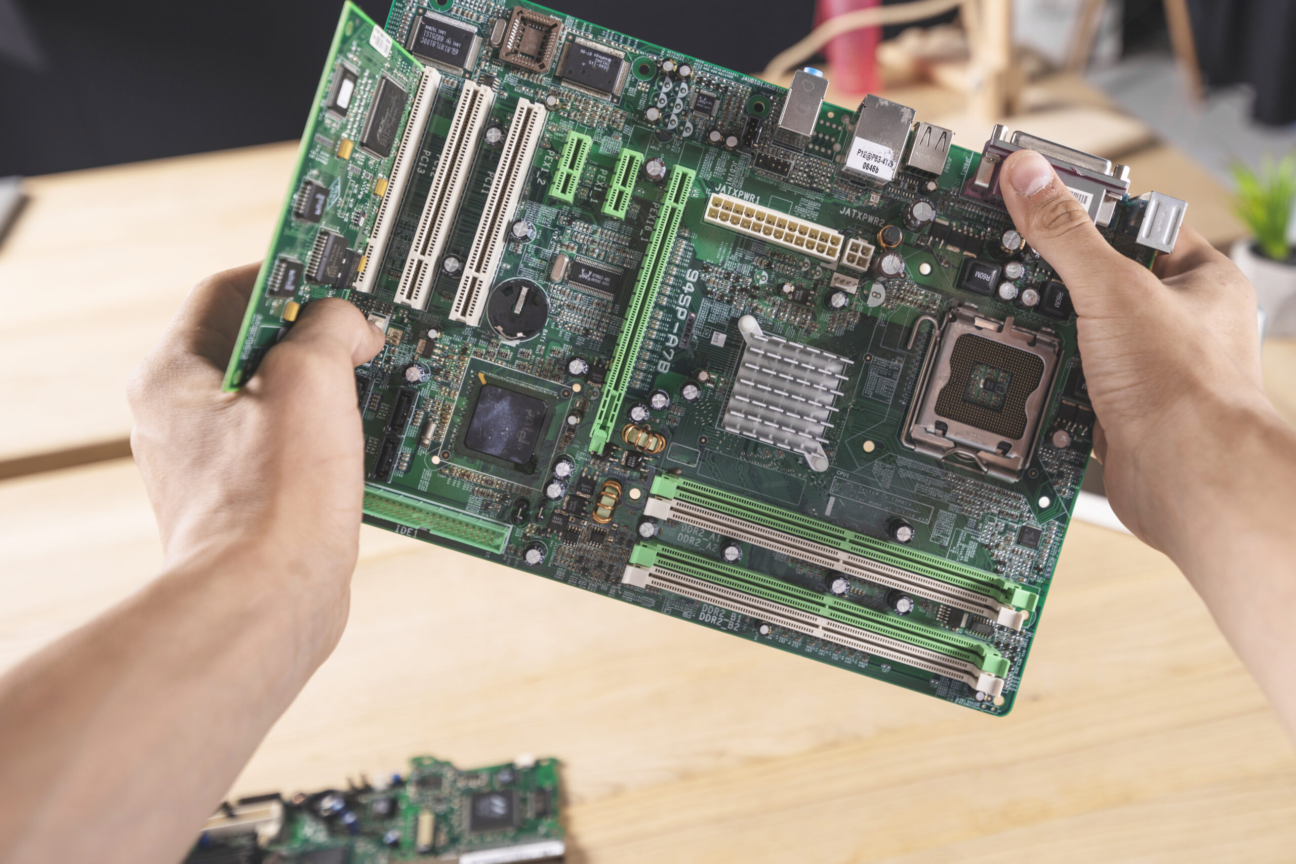 Tại sao nên vệ sinh Laptop định kỳ? Bí quyết giữ máy bền, chạy mượt như mới! 10 close up it male technician holding computer mainboard scaled